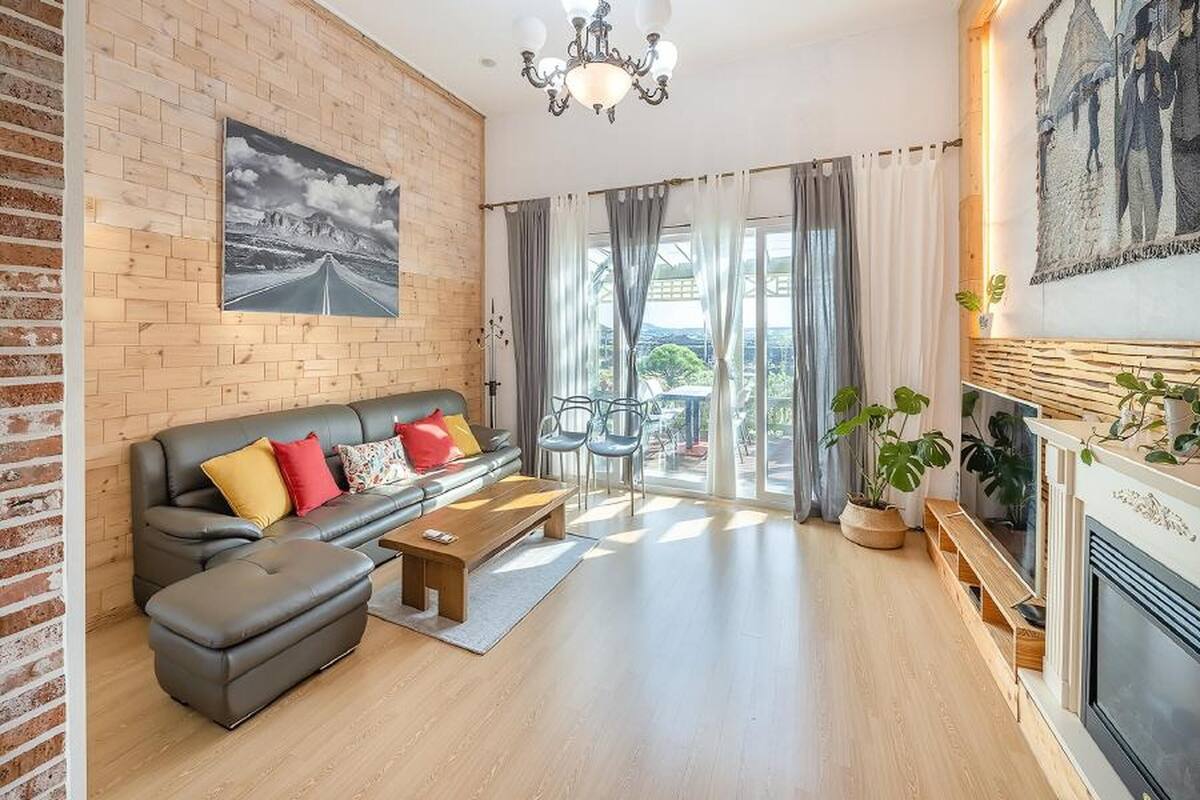 Ein Wohnzimmer mit Backsteinwand, einer Couch, einem Couchtisch und einem Kamin.