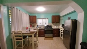 Una cocina funcional con armarios de madera, estufa y refrigerador.
