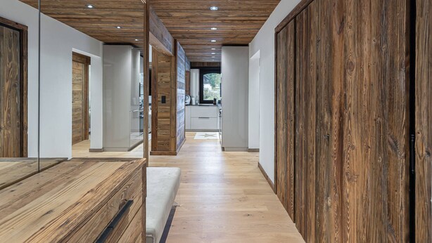 A modern interior with wooden paneling, a kitchen area, and a view to the outside. - Charming 3-BR Apartment in Megève, Near Center, Ski, and Sports Complex (Megève)