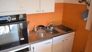 A compact kitchen with a dishwasher, oven, and sink.