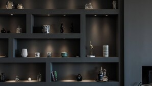Ein stimmungsvolles Interieur mit mehreren Regalen, die verschiedene Dekorationsgegenstände und Bücher präsentieren.