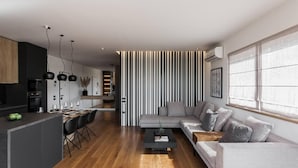 Un soggiorno moderno con un divano, un tavolino da caffè e un'area pranzo con tavolo e sedie.