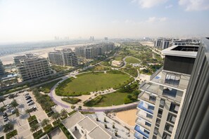 Un immeuble de grande hauteur doté d’un jardin sur le toit, d’un parc circulaire et d’un espace de stationnement pour voitures.