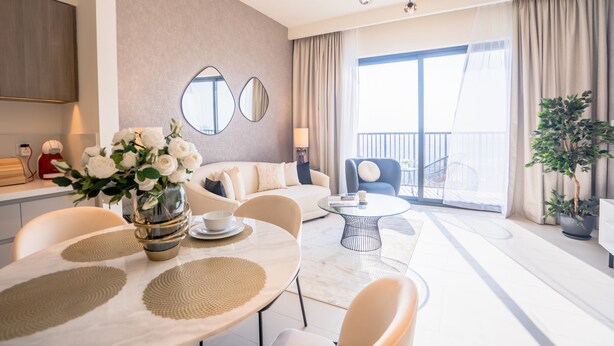 A modern living room with a dining area, large windows, and a balcony. - Nasma Luxury Stays - Dubai Hills (Dubai)