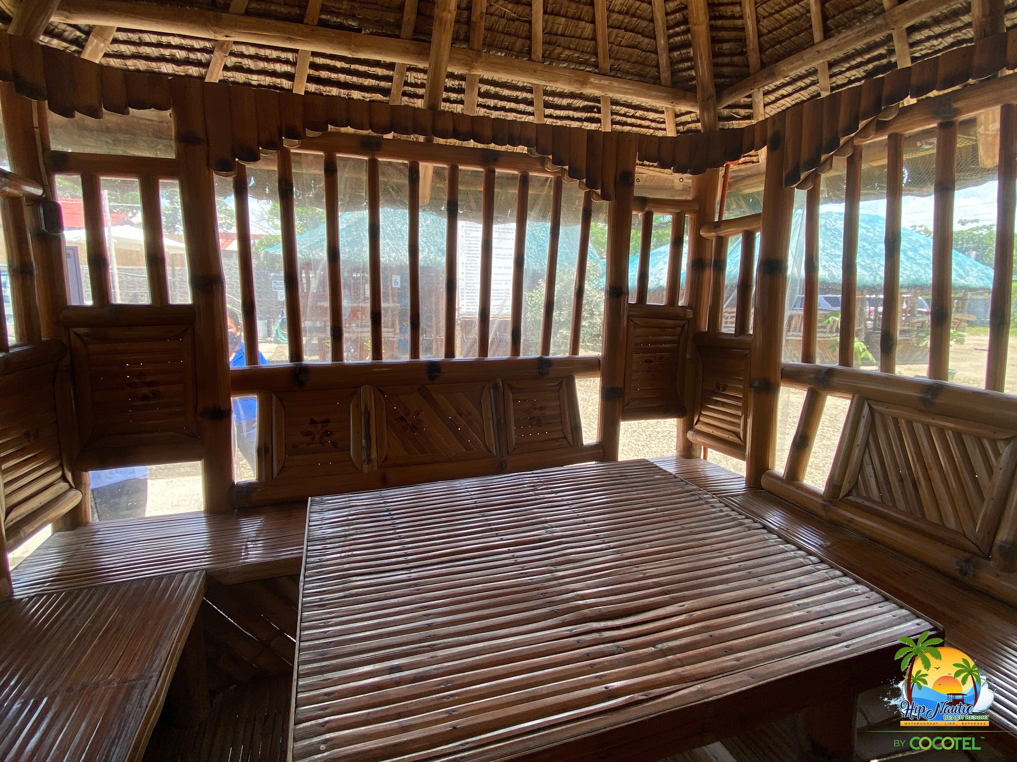 A wooden room with a bed, windows, and a view of the outdoors.