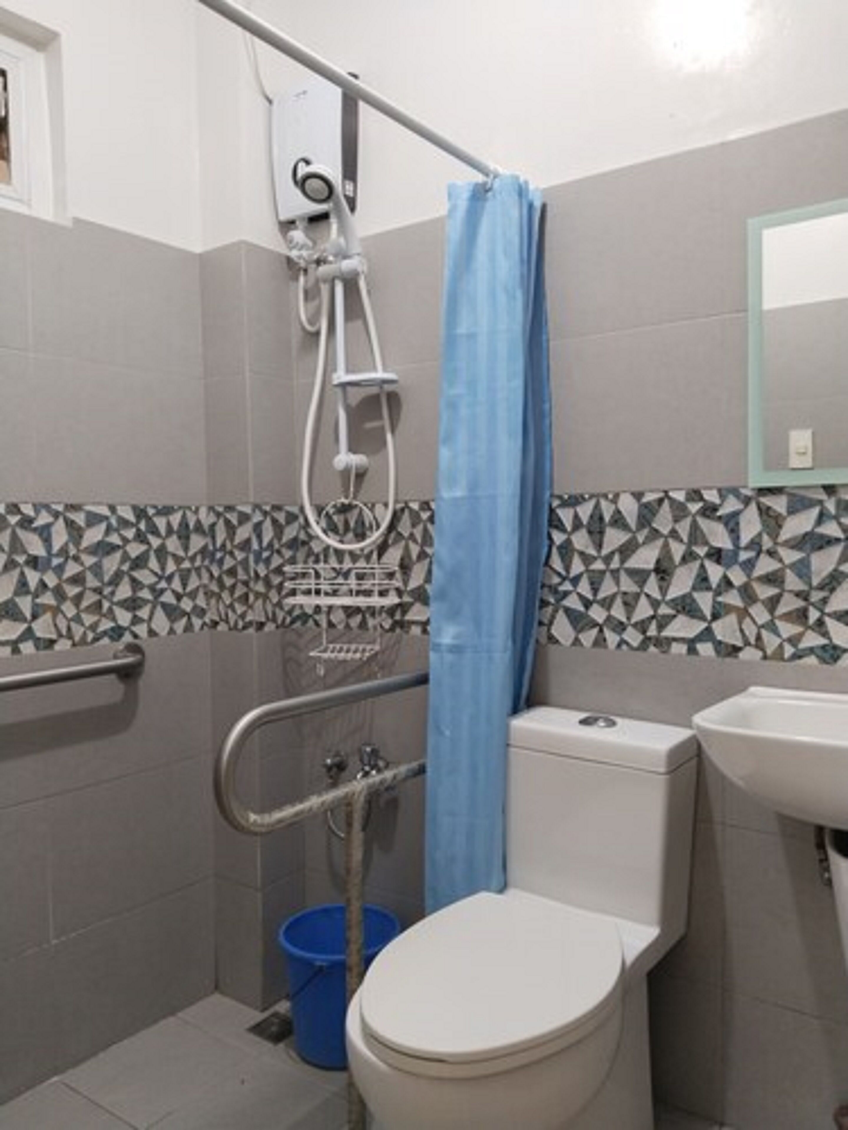 A bathroom with a shower, toilet, and sink.