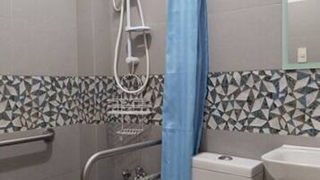 A bathroom with a shower, toilet, and sink.
