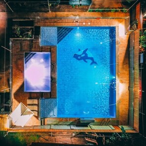 Una piscina con un sommozzatore, circondata da pareti in legno e un'ampia finestra.