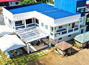 A modern hotel with a blue roof, multiple balconies, and a covered outdoor dining area. - Hip Nautic Beach Resort by Cocotel (Lian)