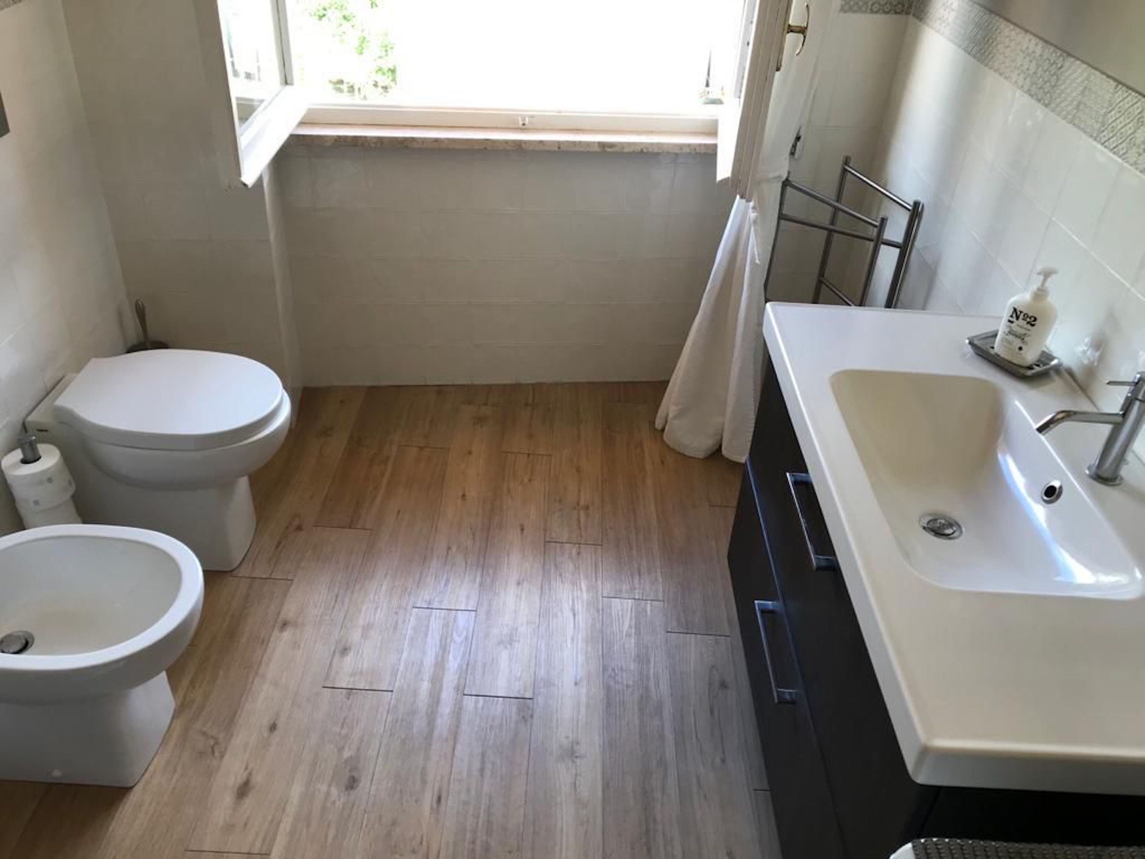 Un baño con inodoro, bidé y lavamanos.
