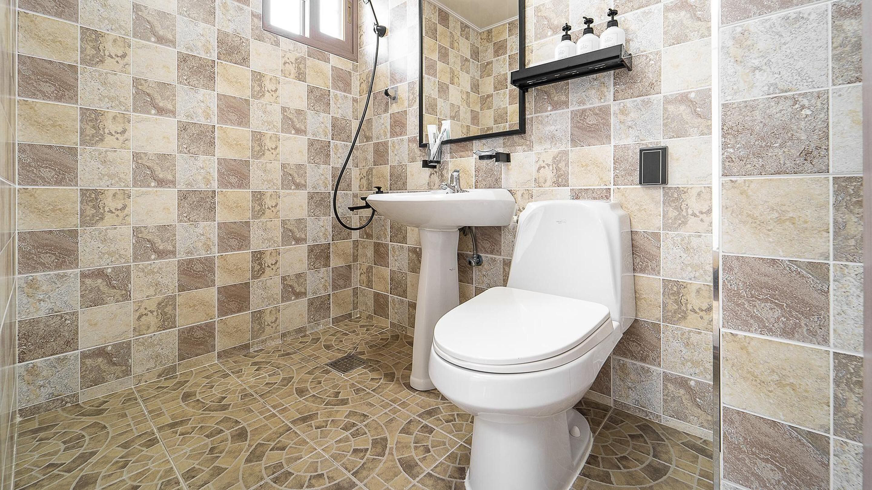 A bathroom with a toilet, sink, and shower.