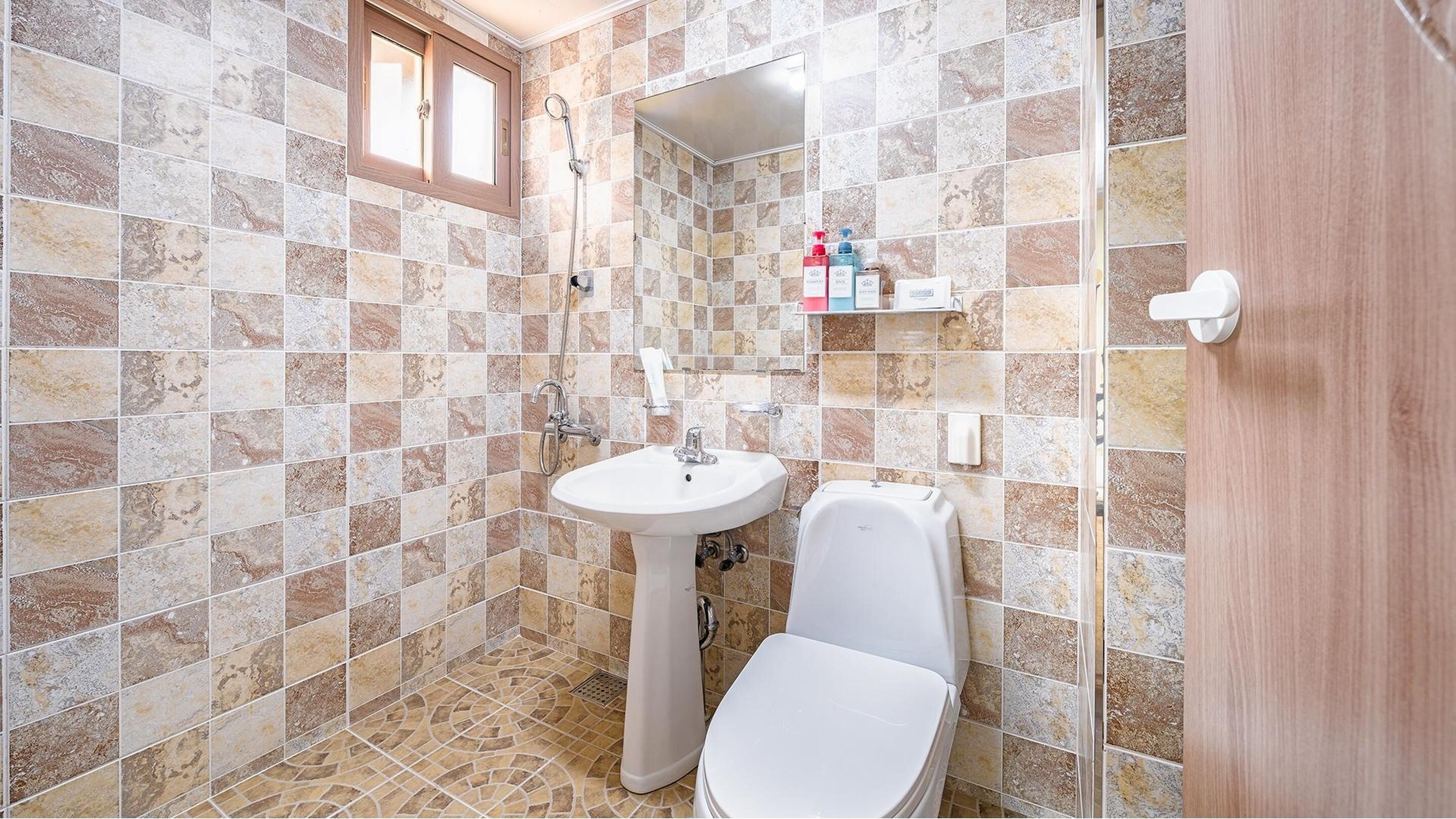 Un baño con lavamanos, inodoro y ducha blancos.