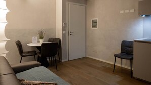 Een functionele ruimte met kitchenette, eethoek en zithoek.