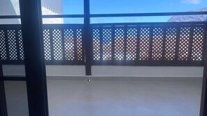 A balcony with a lattice fence, a clear sky, and a distant mountain view. - Los Gigantes, Fantastic 1 Room, balcony (Acantilados de Los Gigantes)