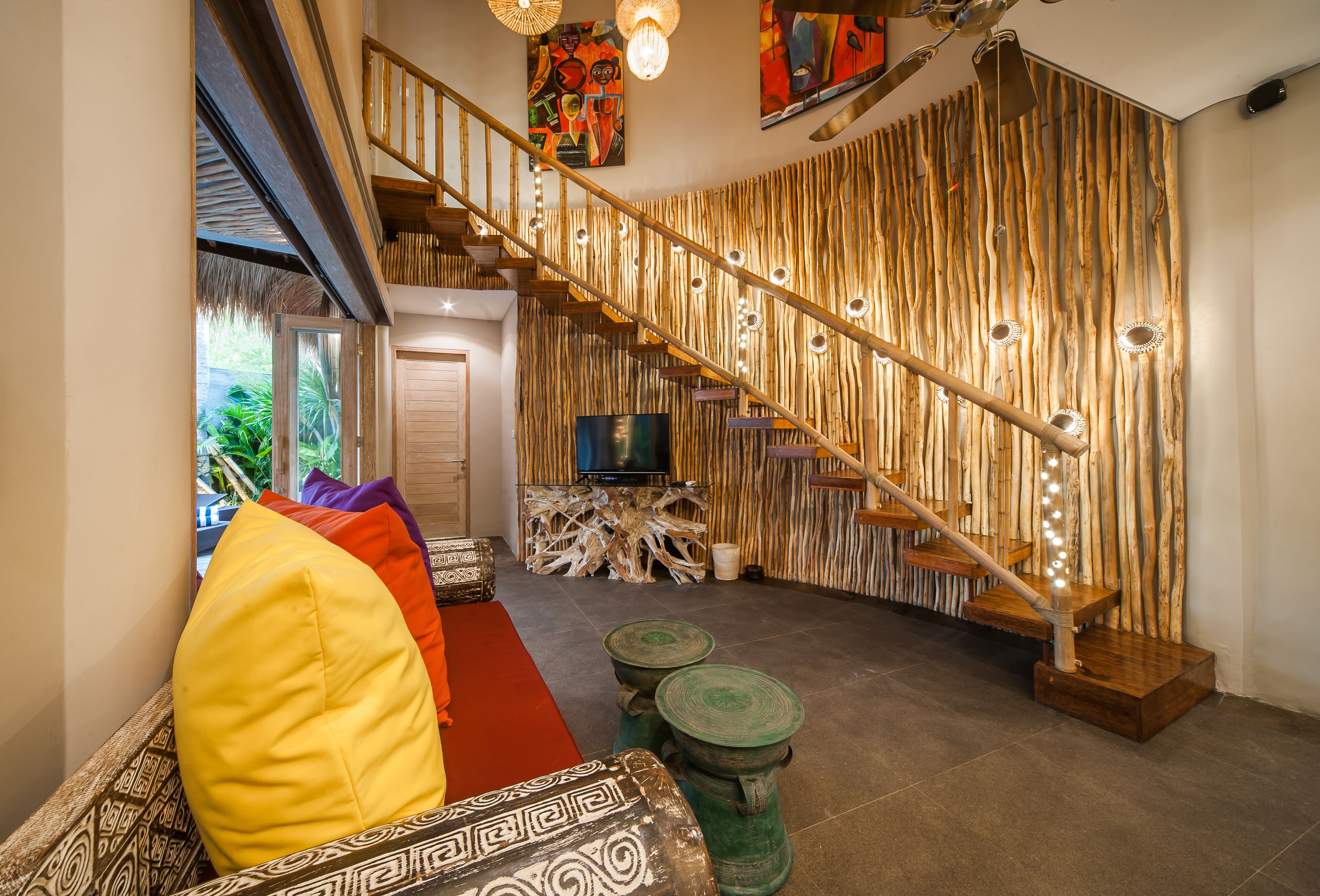 Un interior moderno con una escalera de madera, un televisor de pantalla plana y una alfombra roja.