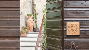 A wooden door with a metal handle and a sign with text. - Corte Trepée, in the old town of Piovere (Tignale)