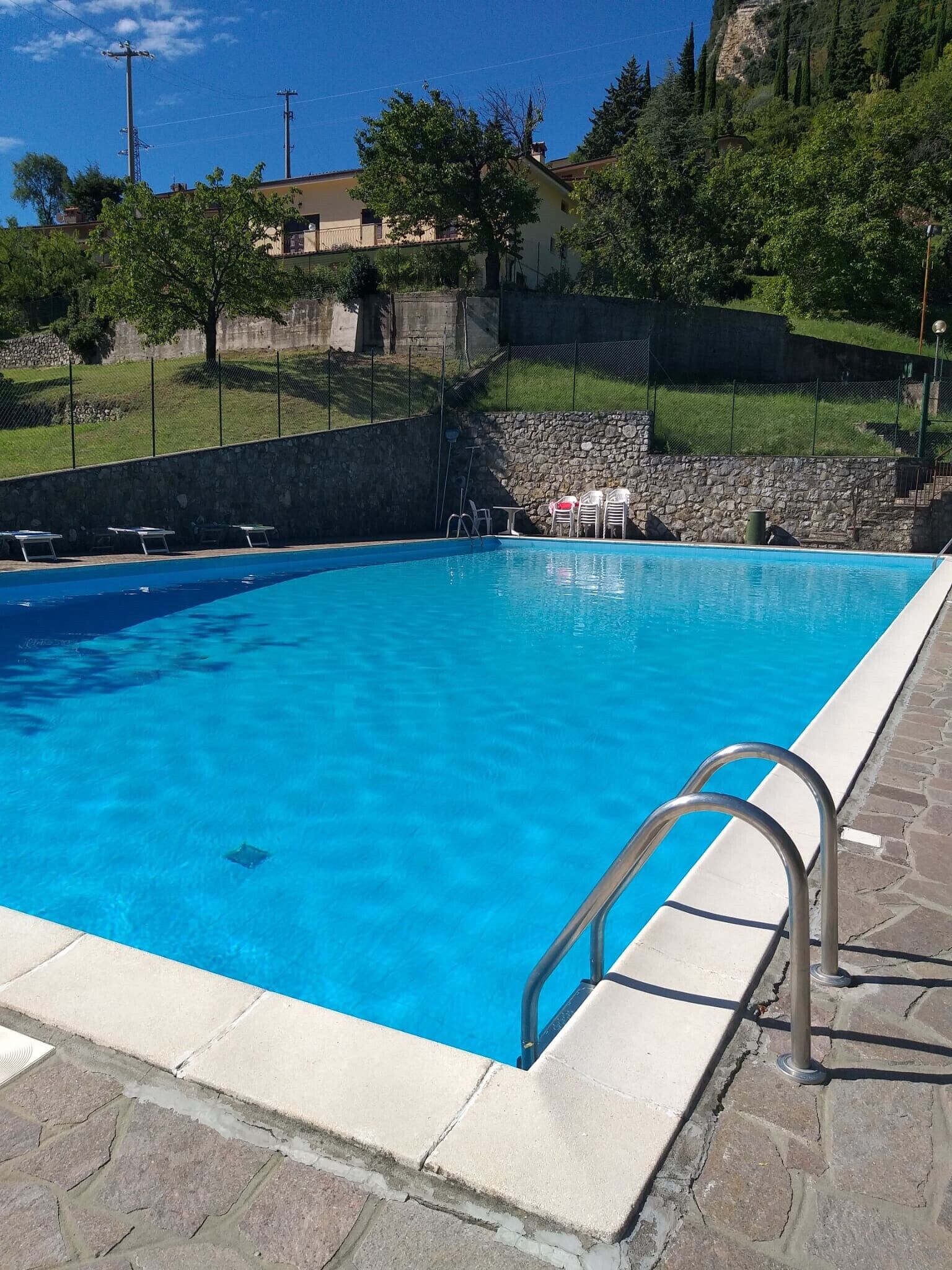 A rectangular swimming pool with a metal ladder on the right side.