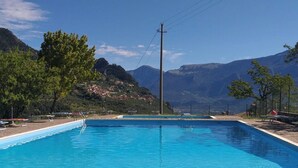 A rectangular swimming pool with clear blue water, surrounded by trees and mountains in the background. - Corte Trepée, in the old town of Piovere (Tignale)