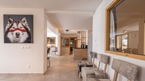 A modern interior with a kitchen, dining area, and a hallway with seating. - "Loft Alpin" dans la Résidence l'Orée des Pistes (Oz)