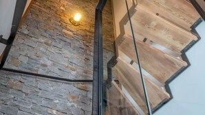 Un escalier moderne avec un mur en pierre et des marches en bois.