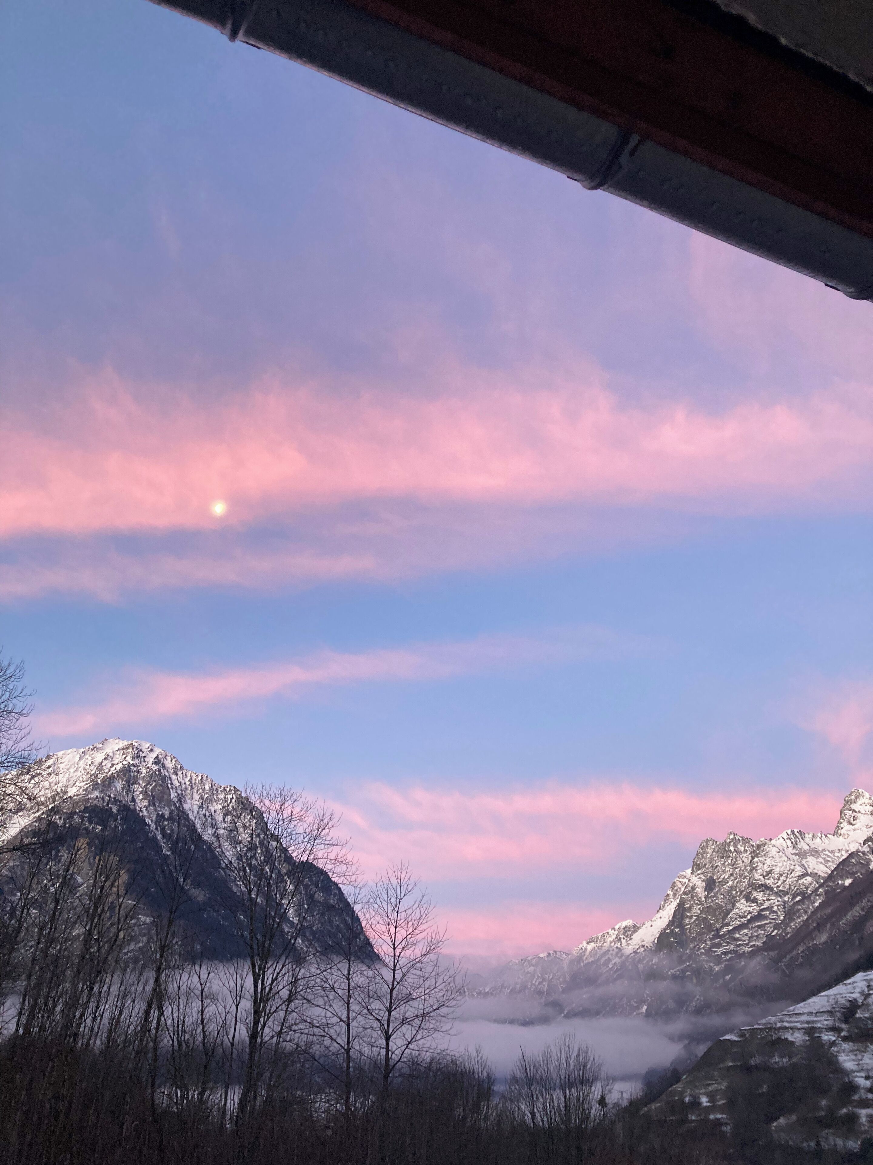 Een bergachtig landschap met besneeuwde toppen en een heldere lucht.