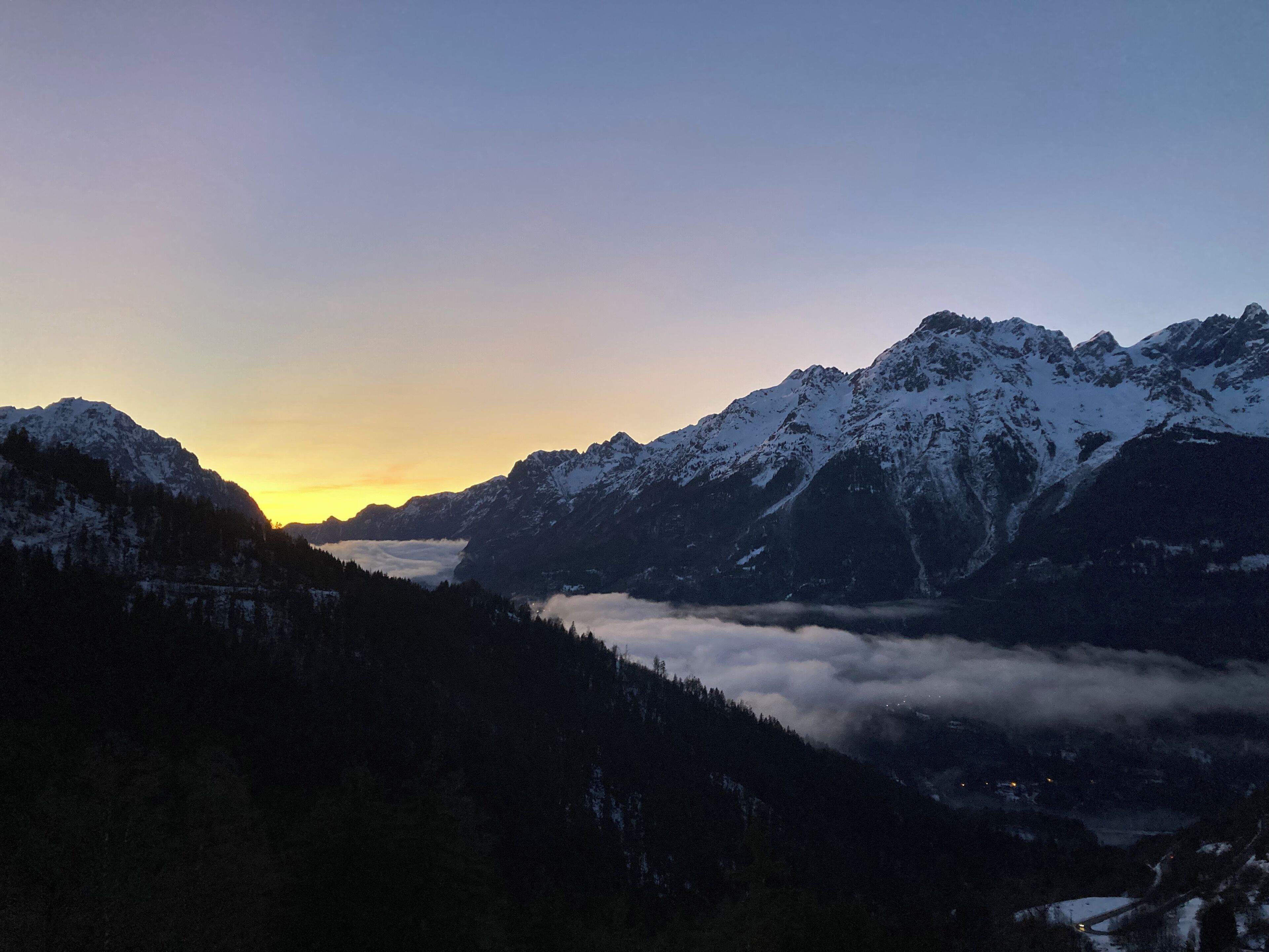 A mountainous landscape with snow-covered peaks and a valley below.