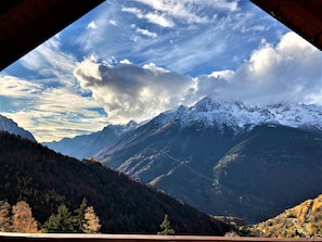 A mountainous landscape with snow-capped peaks and a forested valley.