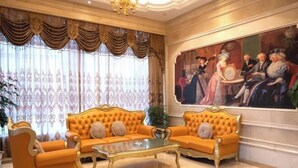 A luxurious room with a large sofa set, a glass coffee table, and a classical painting on the wall. - Vienna International Hotel (Tianmen Wanda Plaza Donghu Branch) (Tianmen)