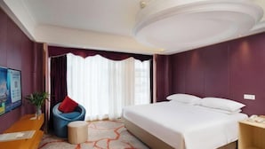 A hotel room with a large bed, a desk, a chair, and a small table. - Vienna International Hotel (Tianmen Wanda Plaza Donghu Branch) (Tianmen)