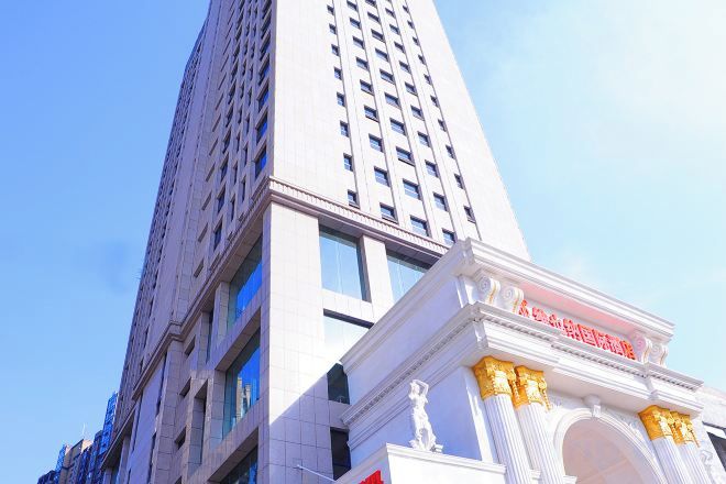 A tall building with a classical architectural style, featuring a prominent entrance with columns and a decorative archway.