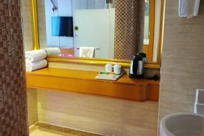 A hotel bathroom with a wooden vanity, a large mirror, and toiletries on the counter. - Vienna International Hotel (Tianmen Wanda Plaza Donghu Branch) (Tianmen)