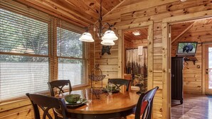 A wooden interior with a round dining table, chairs, and a chandelier. - Papa Bear, Hot Tub, WIFI,  $560 FREE tickets each paid day!!! (Sevierville)
