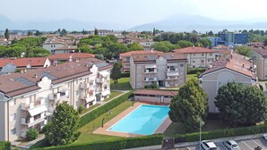 Zona residencial con edificios de apartamentos, una piscina y vistas al mar.