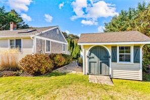 A residential property with a detached house, a garage, and a small shed.