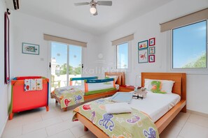 A hotel room with two beds, a red chair, and a balcony with a view. - Villa Hanna - 3 Bedroom Villa in Kapparis, Protaras (Protaras)