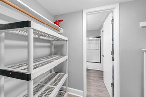 Une pièce de rangement avec des étagères et une bouilloire rouge.