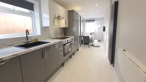 Moderni keittiö, jossa on sisäänrakennettu uuni, pesuallas ja ikkuna.