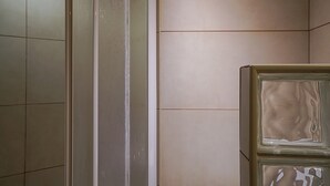 A bathroom with tiled walls, a glass shower enclosure, and a beige cabinet. - Selway Green Apartment, Wifi, Swimming Pool !New! (Quarteira)