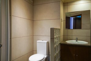Ein Badezimmer mit Toilette, Waschbecken und Spiegel.