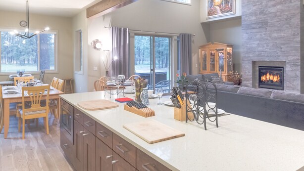 Une cuisine moderne dotée d’un grand îlot central, de meubles en bois et d’une cheminée.