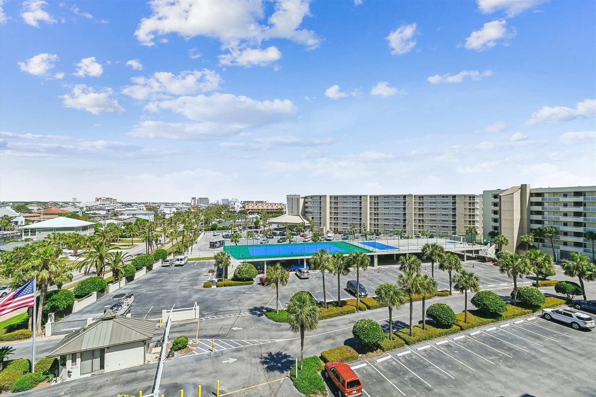 A hotel with a large parking lot, multiple floors, and a prominent blue-roofed building.