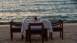 A table set for two on a beach with a view of the ocean. - Sunbird Chintheche Inn (Chintheche)