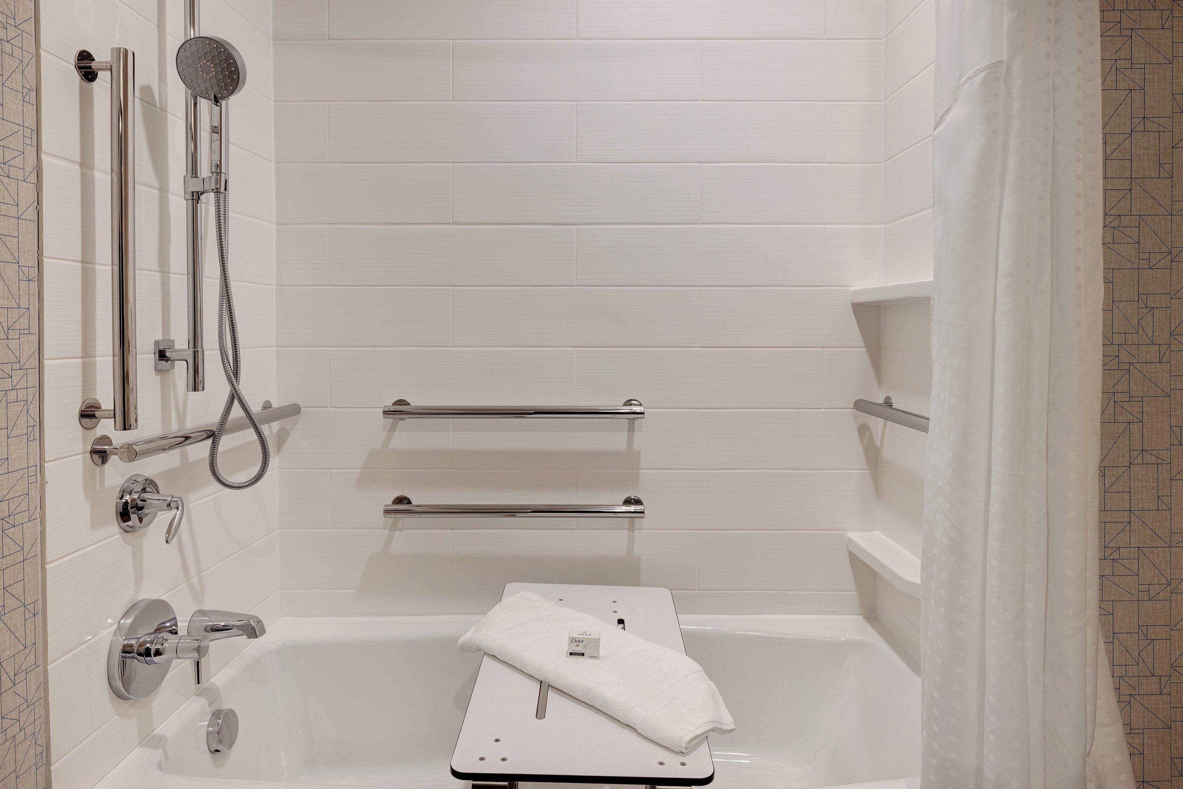 A modern bathroom with a bathtub, a showerhead, and a towel rack.
