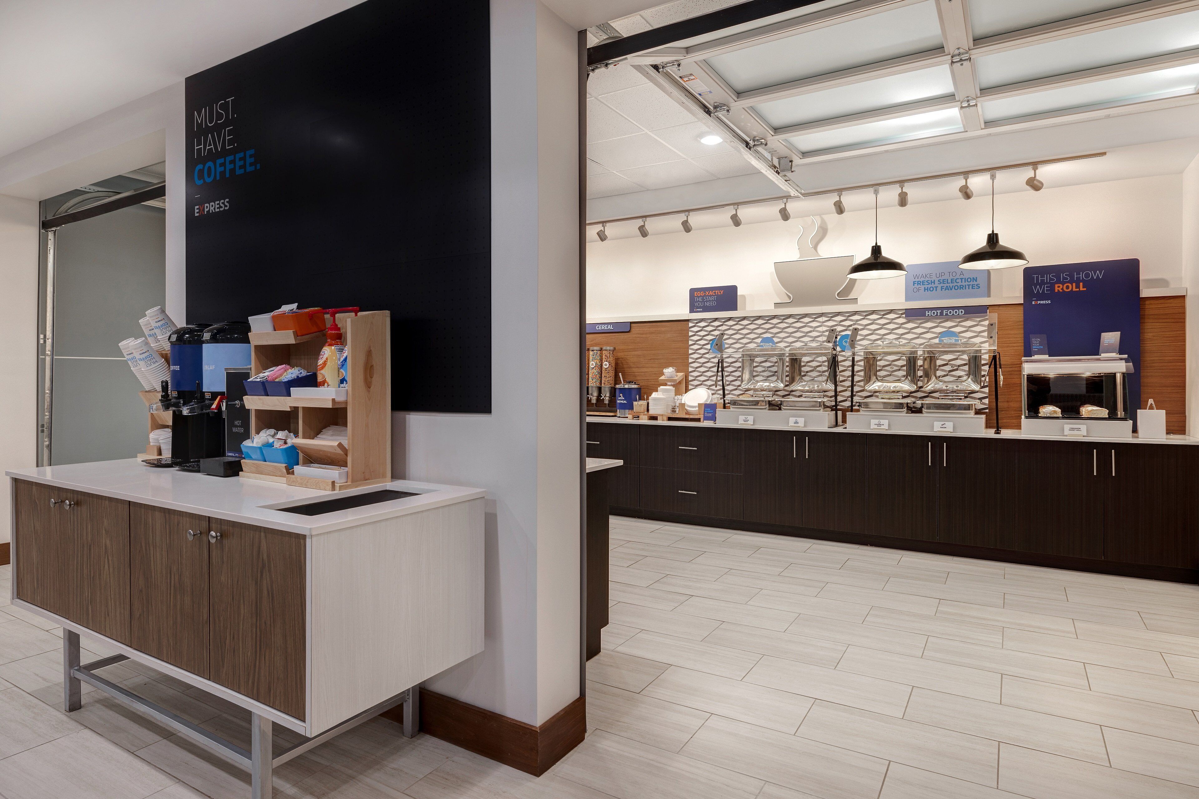 A modern coffee shop with a counter, coffee machines, and a sign that reads "MUST. HAVE. COFFEE."