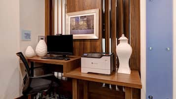 Un escritorio de madera con una computadora, una impresora y objetos decorativos.