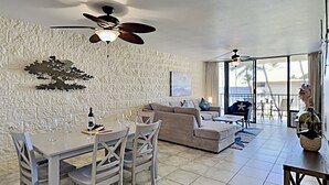 A living room with a dining area, a sofa, and a ceiling fan. - Where Blue Waters Beckon Maalaea Remodeled 2BR Condo Ocean Views Harbor (Maalaea)