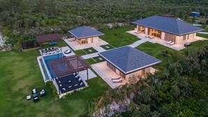 Ein modernes Haus mit Schwimmbad, zwei Gästezimmern und einer Terrassenfläche.