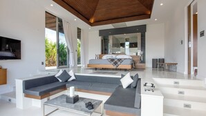 Ein modernes Wohnzimmer mit einem Ecksofa, einem Couchtisch und einem Fernseher.