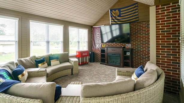 Una sala de estar con chimenea, televisor y refrigerador Coca-Cola.