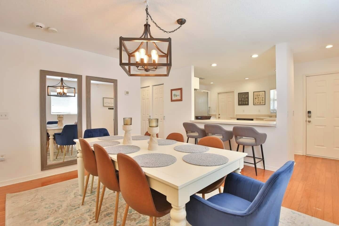 Un coin repas comprenant une table rectangulaire, six chaises et un lustre.